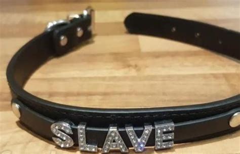 A black collar with the word 'slave' in rhinestones