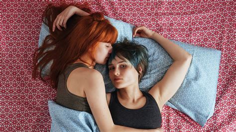 two women in bed together; trans dominant